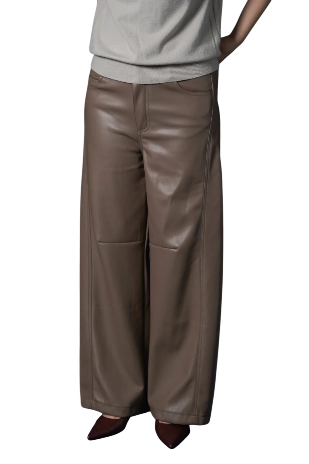 A person wearing brown real leather wide leg trousers paired with a light top